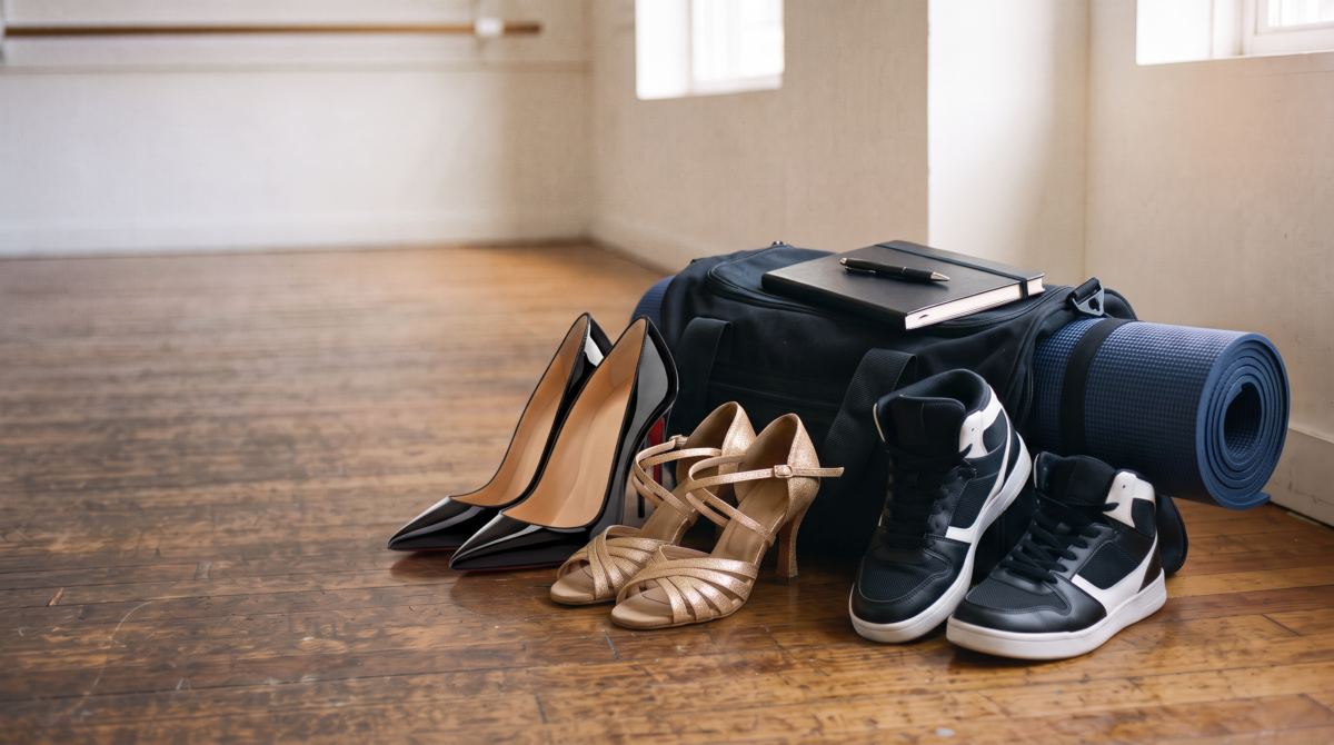 Zapatos de tacón, de baile latino y zapatillas urbanas junto a una bolsa de deporte en un estudio de baile de Life Dance Studio